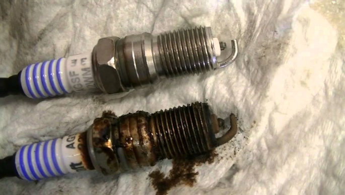 comparing a clean spark plug with a fouled spark plug