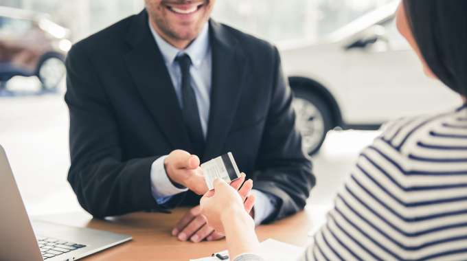 Person at dealership wants to buy a car with a credit card
